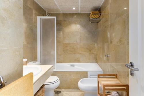 a bathroom with a tub and a toilet and a sink at El Hacho in Manilva
