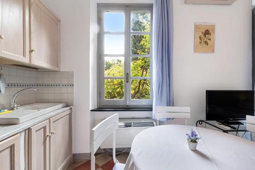 a kitchen with a white table and a window at Monolocale Isotta in Finale Ligure