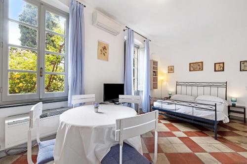 a bedroom with two beds and a table and chairs at Monolocale Isotta in Finale Ligure