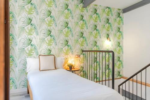 a bedroom with a bed with a tropical wallpaper at Camarón Suite in Granada