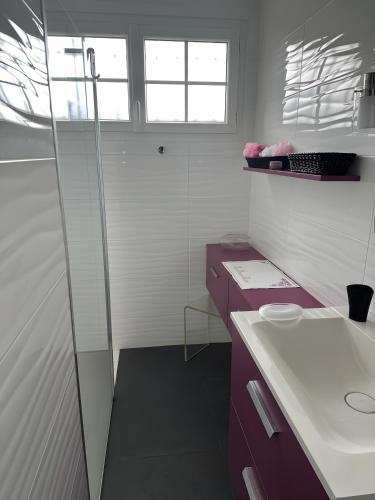 a bathroom with a sink and a glass shower at Maison d'Hôtes - La Marée Hôtes in Piriac-sur-Mer