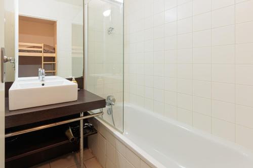 a white bathroom with a sink and a shower at Appartement - Terrasses De L'Océan in Moliets-et-Maa