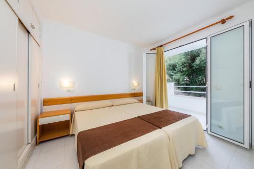 a bedroom with a bed and a large window at Apartament Massanet bc in Canyamel