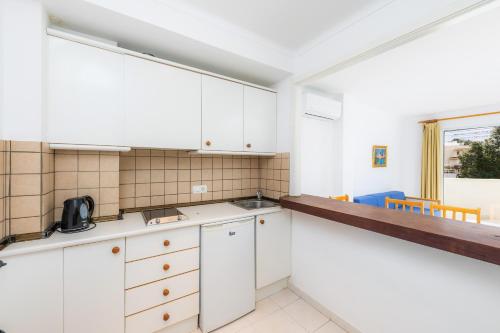 a kitchen with white cabinets and a window at Apartament Massanet bc in Canyamel