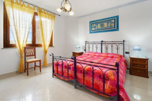 a bedroom with a bed and a chair at La Pineta in SantʼAntìoco