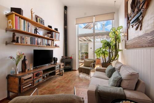 a living room with a couch and a television at Casa Do Limoeiro in Nora