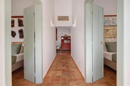 a hallway with two beds and a kitchen in a room at Casa Do Limoeiro in Nora