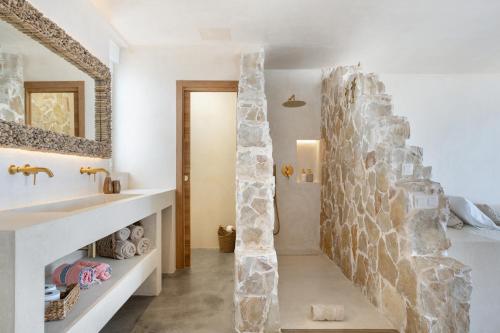 a bathroom with a stone wall next to a sink at Casa Marea - Villa Con Jacuzzi in Corralejo