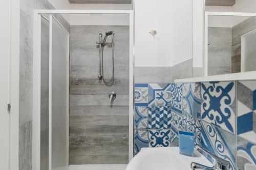 a bathroom with a shower with blue and white tiles at Casa Petros in Marsala