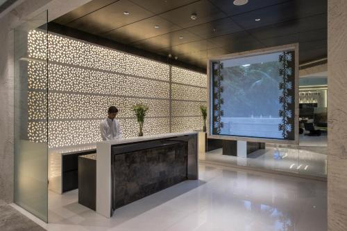 a man standing in a lobby with a large screen at Eastin Residences Vadodara in Vadodara