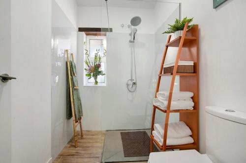 a bathroom with a shower and a shelf with towels at Los Cipreses in Ingenio