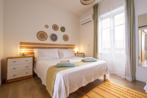 a bedroom with a large white bed and a window at Mira casa in Spadafora