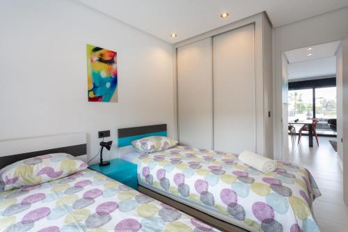 a bedroom with two beds and a dining room at Apartment in Mil Palmeras in Pilar de la Horadada