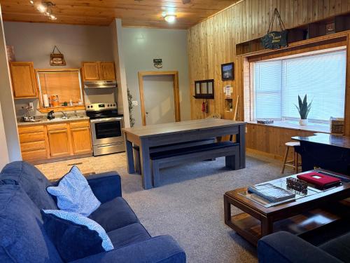 a living room with a blue couch and a table at Pool Table & Hot tub - closest place to the GAP trail in Ohiopyle in Ohiopyle