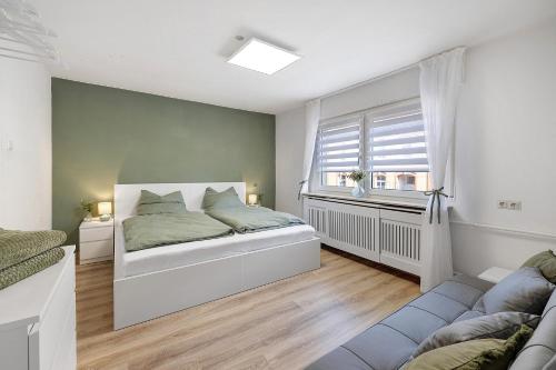 a white bedroom with a bed and a window at Haus Flora Bianca in Albstadt