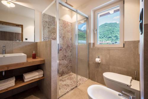 a bathroom with a shower and a toilet and a sink at Sommersbergerhof 1935 in Bressanone