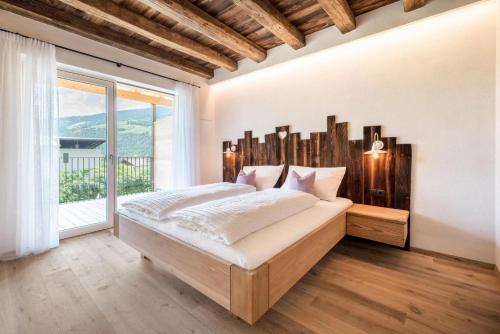a bedroom with a large bed and a large window at Sommersbergerhof 1935 in Bressanone