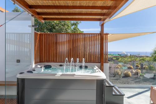 a jacuzzi tub in a patio with a fence at El Alcaidón in Tías