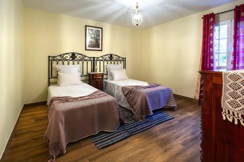 a bedroom with two beds and a window at Villa Rústica - Casa da Lurdes in Ribeira Brava