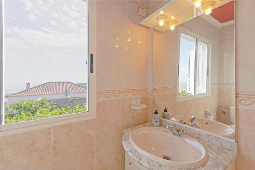 a bathroom with a tub and a sink and a window at clemente house,private pool in Arafo