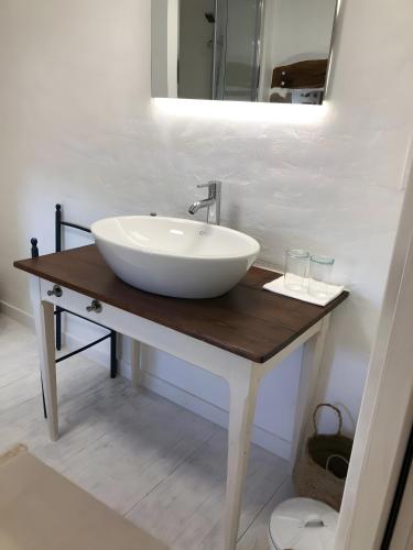 a white sink on a wooden table in a bathroom at Chambre d'hôtes - Els Pomers in Soubrebost