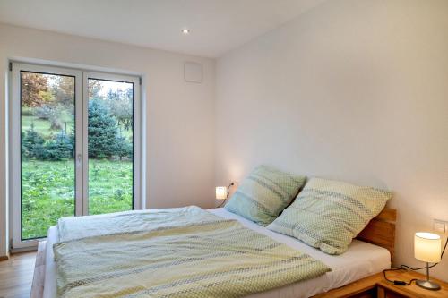 a bedroom with a bed and a large window at Tanne in Ravensburg