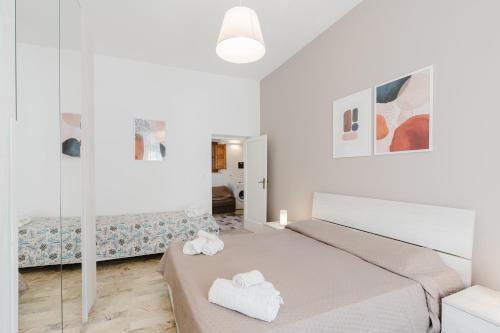 a white bedroom with a bed and a mirror at Sea Nest in Balestrate