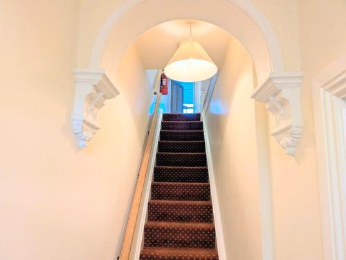 a hallway with a stairway with a stair case at Riverside House - with parking in York