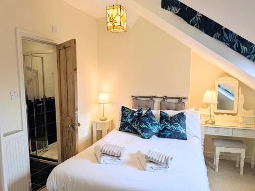 a bedroom with a large white bed with blue pillows at Riverside House - with parking in York
