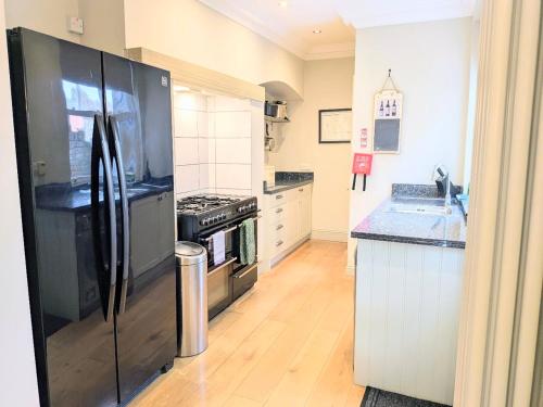 a kitchen with a black refrigerator and a stove at Riverside House - with parking in York
