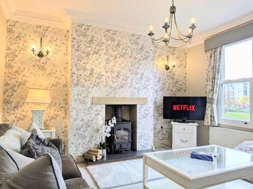 a living room with a fireplace and a tv at Riverside House - with parking in York