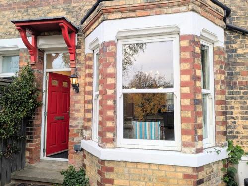 a red door and a window on a brick house at Riverside House - with parking in York