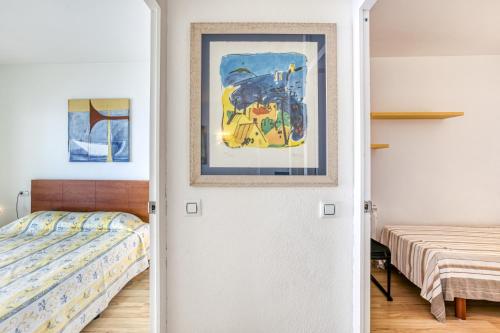 a bedroom with a bed and a painting on the door at Marinada in L'Escala
