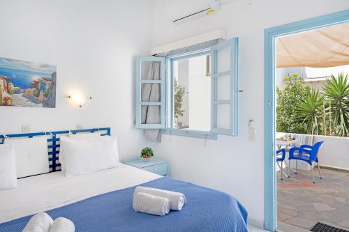 a bedroom with a bed and a window and a patio at Pico Bello Patmos 14 in Patmos