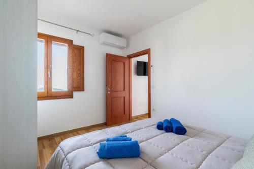 a bedroom with a large bed with blue pillows on it at Casa Jerzu S'essia de su santu in Jerzu