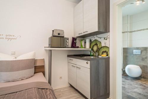a small kitchen with a sink and a microwave at Apartment mit Kaffeeküche für Zwei in Meersburg