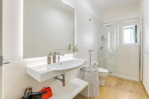 a white bathroom with a sink and a toilet at Vico21 nel centro di Modica in Modica