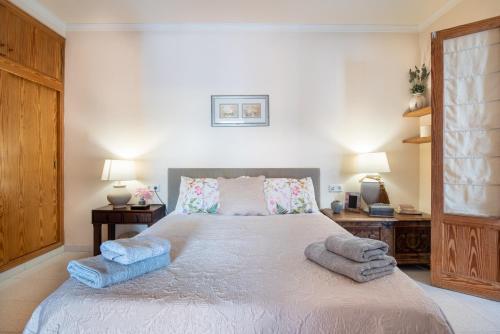 a bedroom with a large bed with blue towels on it at Apartament Carla in Port de Soller