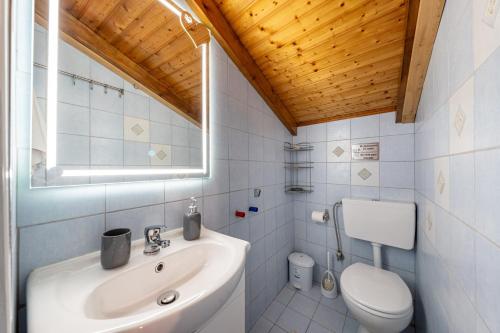 a white bathroom with a sink and a toilet at Kate House in Ágios Matthaíos