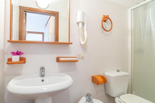 a bathroom with a sink and a toilet and a mirror at Trilocale N8 - Porto Mannu in Palau