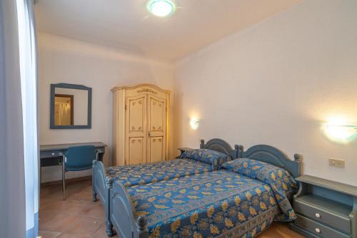 a bedroom with a bed and a desk and a mirror at Trilocale N8 - Porto Mannu in Palau