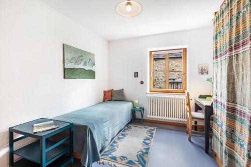 a bedroom with a bed and a desk and a window at Sonnige Wohnung im Markgräflerland in Efringen-Kirchen