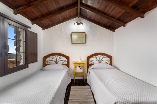 two beds in a room with a window at Tesbabo Rural - Camelia in Mocanal