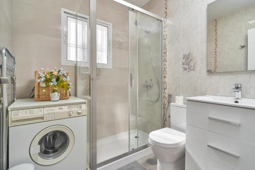 a bathroom with a washing machine and a shower at Entre montañas in Árchez