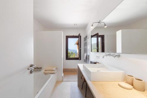 a white bathroom with a sink and a mirror at Dream Property in Alconasser in Sóller