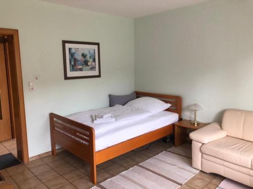 a small bedroom with a bed and a couch at Ferienwohnung Mi Ka mit Garten in Limburg an der Lahn