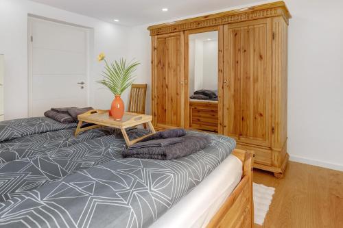 a bedroom with a large bed and a wooden cabinet at am Hochrhein Desko in Gailingen