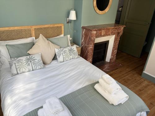 a bedroom with a large bed with a fireplace at Trois Clés Apartment 1 - 1 bed in Eymet