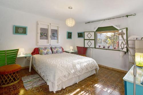 a bedroom with a bed and two chairs and a window at Finca Fani 4 in Agüimes
