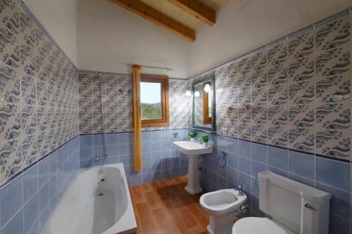 a bathroom with a tub and a toilet and a sink at Cas Cans in Artá